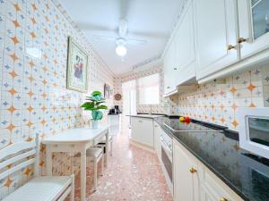 cocina con armarios blancos y mesa en Apartamento NINA, 3 hab, 2 baños, playa, a/a,6 pers, en Salou