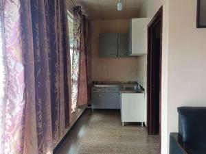 a small kitchen with purple curtains and a sink at ROYAL HOTEL in Juba