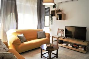 a living room with a couch and a flat screen tv at Reformado Coqueto Fleming a 5 minutos Mezquita WIFI AIRE POSIBILIDAD PARKING in Córdoba