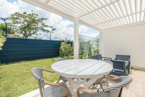 einen weißen Tisch und Stühle auf einer Terrasse in der Unterkunft Amazing 1BR apt Green One Playa Dorada in Muñoz