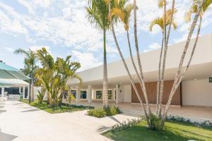 ein Gebäude mit Palmen davor in der Unterkunft Amazing 1BR apt Green One Playa Dorada in Muñoz