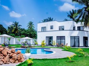 a white house with a swimming pool and a yard at homeland bro in Dar es Salaam