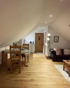 a living room with a table and a couch at The Loft - beautiful countryside apartment in Cullompton