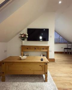 a living room with a coffee table and a flat screen tv at The Loft - beautiful countryside apartment in Cullompton