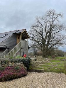 a house with a fence in front of it at The Loft - beautiful countryside apartment in Cullompton