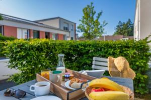 聖埃爾布蘭的住宿－色賴斯南特亞特蘭蒂斯旅館，一张桌子,上面放着一盘食物和一篮香蕉