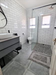 ein weißes Bad mit einem Waschbecken und einer Dusche in der Unterkunft 5 Clifton Road in Nottingham Road