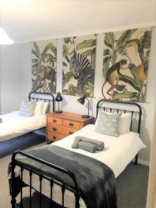 a bedroom with two beds and a mural of animals at 5 Clifton Road in Nottingham Road
