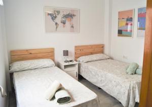 a room with two beds and a table at Reformado Coqueto Fleming a 5 minutos Mezquita WIFI AIRE POSIBILIDAD PARKING in Córdoba
