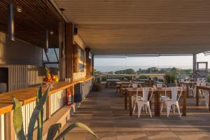 a restaurant with tables and chairs on a patio at Anastasio Hotel & Beach Club in José Ignacio