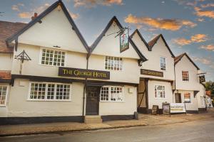 un edificio blanco con un cartel que lee el hotel Grove en The George Hotel, Dorchester-on-Thames, Oxfordshire, en Dorchester on thames