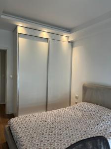 a bedroom with a bed and two sliding glass doors at Ani’s apartment in Pristina