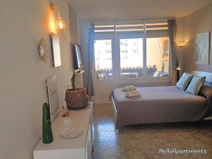 a small bedroom with a bed and a window at Arena Beach by HelloApartments in Puerto de Santiago