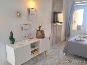 a white cabinet in a room with a bed at Arena Beach by HelloApartments in Puerto de Santiago