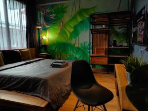 1 dormitorio con 1 cama y 1 silla negra en โรงแรม บอร์ดดิ้งเฮ้าส์, en Ban Bang Yai Chuai