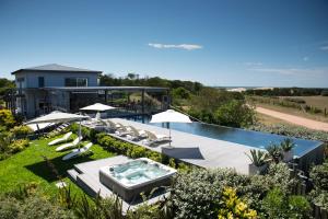 a backyard with a swimming pool and a house at Anastasio Hotel & Beach Club in José Ignacio