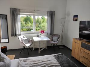 a bedroom with a table and chairs and a window at Ferienwohnung Morgensonne in Bad Feilnbach