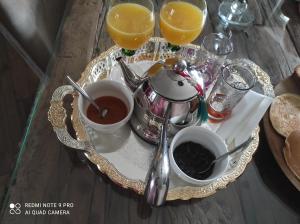 a table with a tray of tea and orange juice at Belle suite parentale in Laize-la-Ville