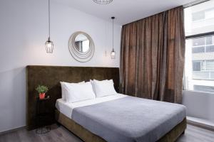 a bedroom with a large bed and a window at Enattica Monastiraki Living in Athens