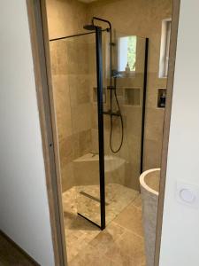 a shower with a glass door in a bathroom at Belle suite parentale 