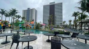 a pool with tables and chairs and a water park at Salinas Premium Resort in Salinópolis