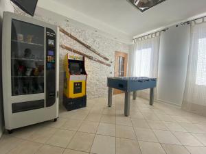 una habitación con una máquina de videojuegos y una mesa de ping pong en Bed & Wellness Fisterre, en Belluno