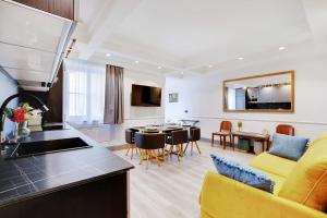 a kitchen and living room with a yellow couch and a table at Magnifique appartement - 2BR - 6P - Place de l'Etoile in Paris