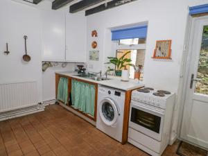 a kitchen with a washing machine and a sink at 26 Llawr Pentre in Colwyn Bay