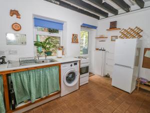 a kitchen with a washing machine and a sink at 26 Llawr Pentre in Colwyn Bay