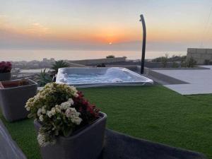 a backyard with a hot tub and some flowers at Infinity House. Ocean View hot tub. in Adeje