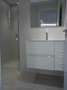 bagno bianco con lavandino e specchio di Villa Infinity Vistas Wiffi y jacuzzi ad Adeje