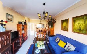sala de estar con sofá azul y mesa en Piso en Bueu a 100 metros de la playa en Bueu
