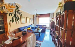 sala de estar con sofá azul y mesa en Piso en Bueu a 100 metros de la playa en Bueu