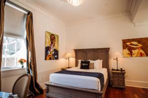Royal Frenchmen Hotel and Bar في نيو أورلينز: غرفة نوم مع سرير مزدوج كبير ونافذة