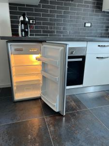an open refrigerator in a kitchen with a microwave at BLAXEJ, nel cuore di Verona, MODERNO ed ELEGANTE, 4 posti letto, Wi-Fi, Self Check In in Verona