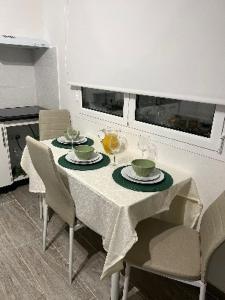 Una mesa de comedor con un mantel blanco y sillas. en Casinha da Palmeira, en Nazaré 7 fotos más