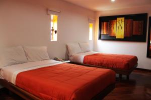 a hotel room with two beds with red covers at HBS Hotel in Manizales