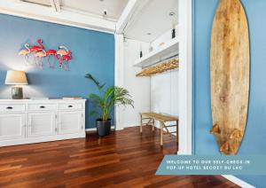 um quarto com uma prancha de surf numa parede azul em becozy du Lac Self-Check In Hotel Riviera Edition em Wädenswil