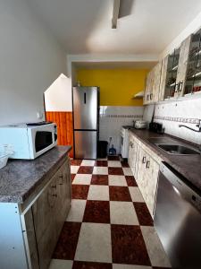 a kitchen with a checkered floor and a refrigerator at Dovolenkovy dom in Ružomberok