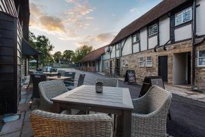 a wooden table and chairs in front of a building at The George Hotel, Dorchester-on-Thames, Oxfordshire in Dorchester on Thames