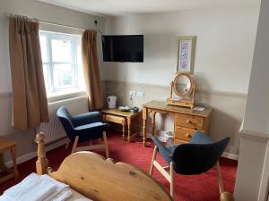 Zimmer mit einem Schlafzimmer mit Spiegel und Stühlen in der Unterkunft The Bullshead, Arthingworth House B&B in Market Harborough