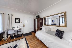 ein Wohnzimmer mit einem weißen Sofa und einem Spiegel in der Unterkunft Julia Metelmann in Santa Barbara