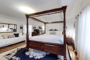 ein Schlafzimmer mit einem Himmelbett und einem blauen Teppich in der Unterkunft Julia Metelmann in Santa Barbara