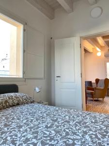 a bedroom with a bed and a chair and a window at Dimore San Giovanni - Puglia Mia Apartments in Monopoli