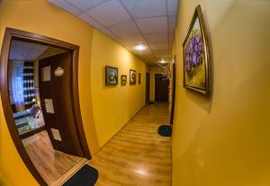 a hallway with yellow walls and a hallway with a door at Kamienica in Płock