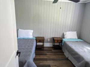 a room with two beds and two tables at Captains Hideaway in Salem