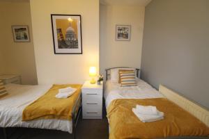 1 dormitorio con 2 camas, tocador y espejo en Clifton House, en Woodhouse