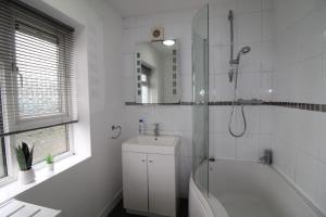 a bathroom with a shower and a tub and a sink at Clifton House in Woodhouse