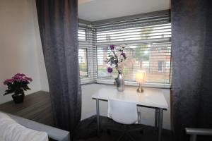 a room with a table and a window with a vase of flowers at Clifton House in Woodhouse