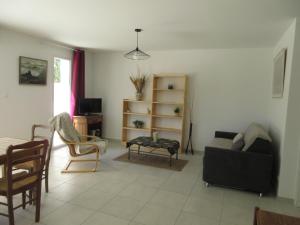 ein Wohnzimmer mit einem Sofa und einem Tisch in der Unterkunft Maison neuve dans Saintes avec terrasse et jardin in Saintes
